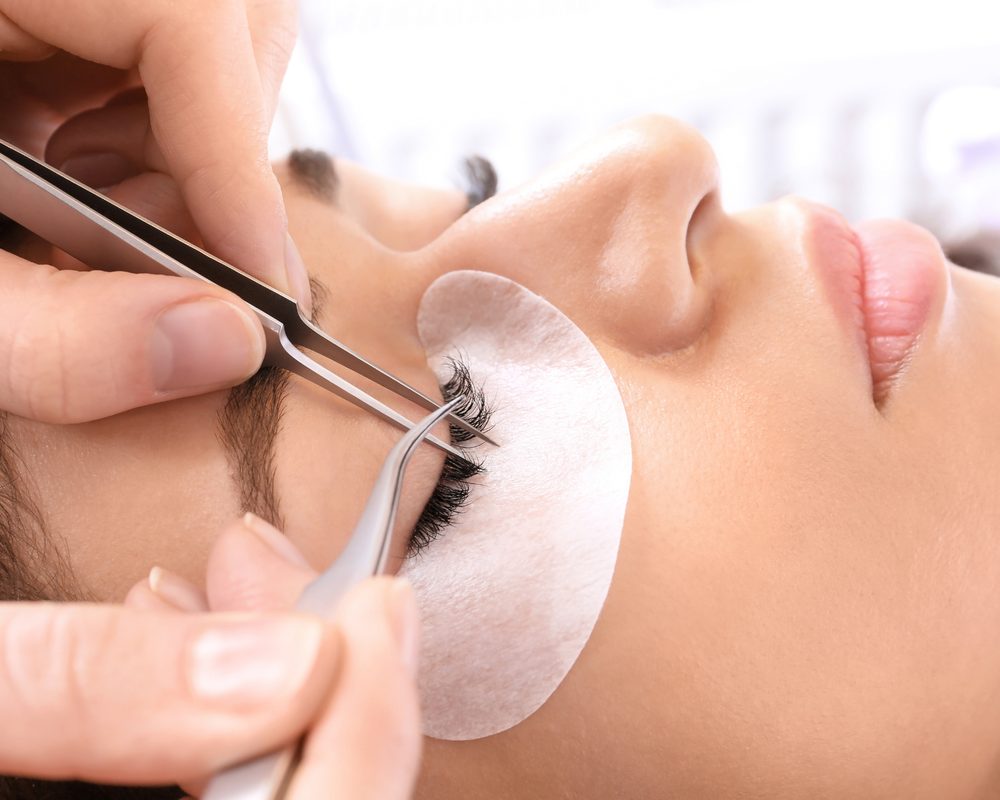 Lash extensions being applied with tweezers
